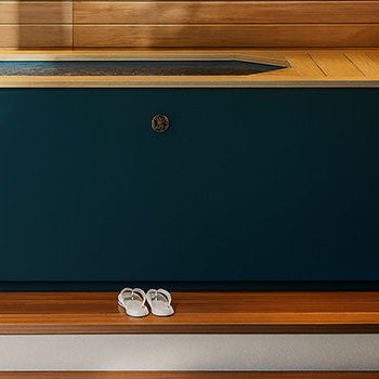 Deep blue modern ice bath in wood-clad spa room with natural lighting and minimal decor.
