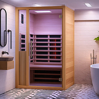 Contemporary indoor infrared sauna with purple lighting in a luxury bathroom with marble walls, herringbone floor tiles, and freestanding bathtub.