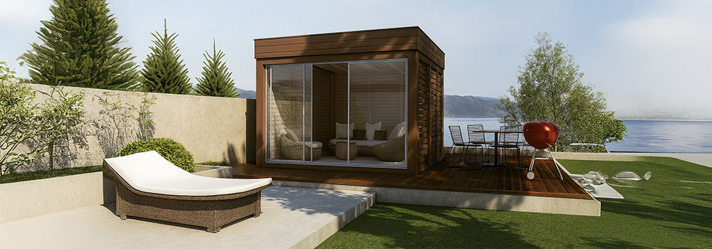 Modern lakeside garden room with wooden deck, sun lounger, and red grill in elegant patio setting.