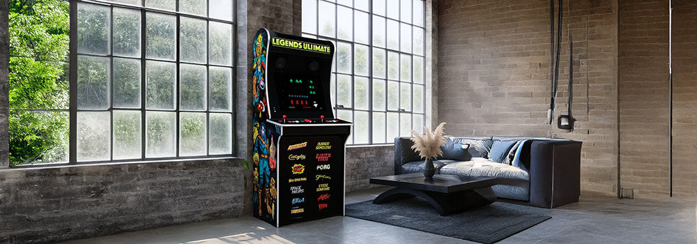 Legends Ultimate arcade machine with classic game art in a modern loft with exposed brick and large industrial windows.