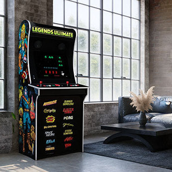 Legends Ultimate arcade machine with classic game art in a modern loft with exposed brick and large industrial windows.