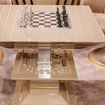 Luxury chess set on a beige game table in a designer billiards room with cue rack and velvet chairs.