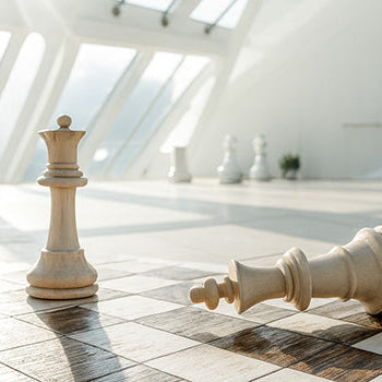 Oversized luxury wooden chess pieces in a sunlit modern atrium with geometric glass walls.