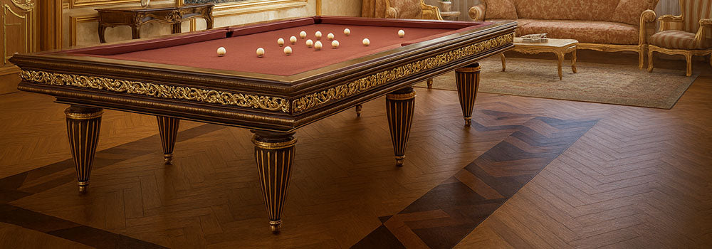ornate burgundy pool table with gold accents in a classical luxury room featuring chandeliers, brocade furniture, and parquet floors.