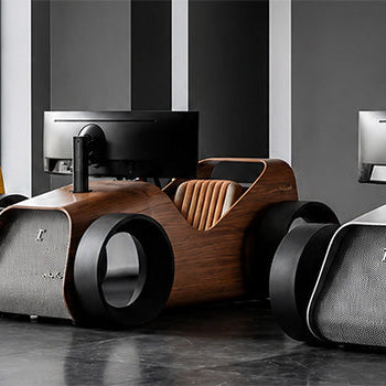 Three luxury car-inspired racing simulator cockpits with integrated monitors in yellow, wood-effect and silver finishes.