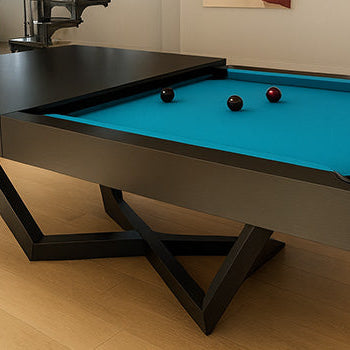 black modern pool table with bright turquoise felt in an industrial loft featuring spiral staircase, brick column, and abstract art.