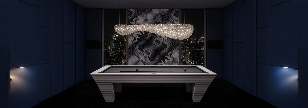 modern gray pool table with black felt under a crystal chandelier in a high-rise room with abstract art and city skyline view.