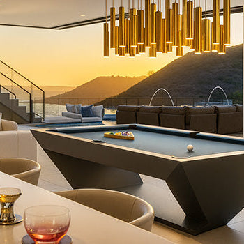 geometric modern pool table in luxury lounge with ocean view at sunset and golden pendant lights.