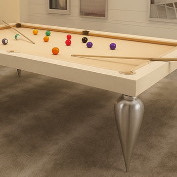 modern light wood pool table with metallic cone legs in a neutral-toned interior with pendant lighting and abstract wall art.