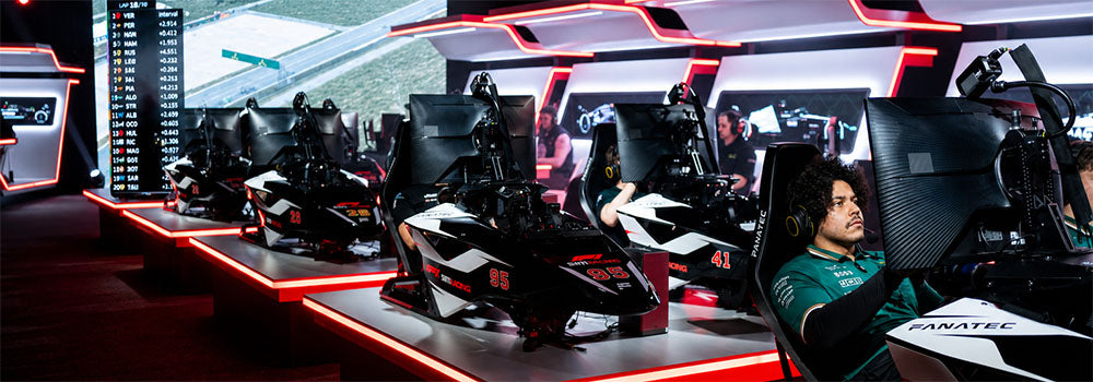 Multi-rig racing simulator centre with drivers, Fanatec equipment and Formula-style cockpits arranged for competitive esports motorsport racing.