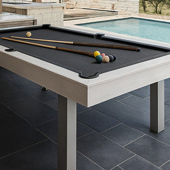 modern outdoor pool table with black felt under a covered patio overlooking a swimming pool and scenic countryside.