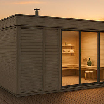 Modern outdoor sauna cabin on a lakeside deck at sunset, surrounded by calm water and lush greenery, with warm interior lighting visible through large glass doors.