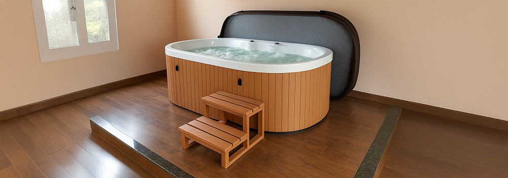 Oval wooden-sided hot tub with white interior and open cover on indoor wooden flooring.