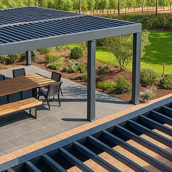 Modern louvered pergola over outdoor dining area beside vineyard under blue sky.
