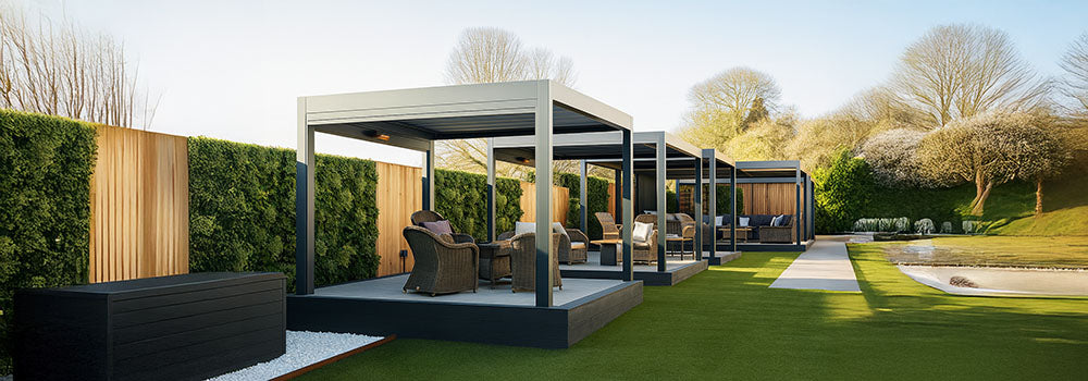 Row of luxury pergolas with wicker lounge sets on raised decks and artificial lawn in a landscaped garden.