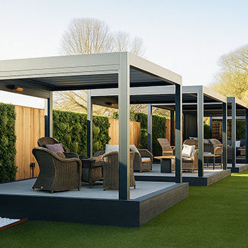 Row of luxury pergolas with wicker lounge sets on raised decks and artificial lawn in a landscaped garden.