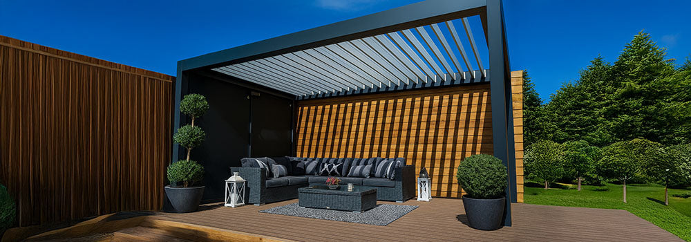 Stylish pergola with adjustable louvres over a dark wicker sofa set and rug, framed by lanterns and potted trees.