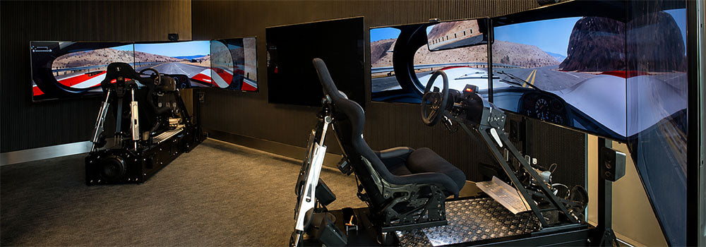 Professional motion racing simulator cockpits with racing seats, steering wheels and immersive triple-screen displays in a dedicated sim racing room.