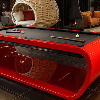 glossy red designer pool table in a contemporary loft-style showroom with modern furniture.