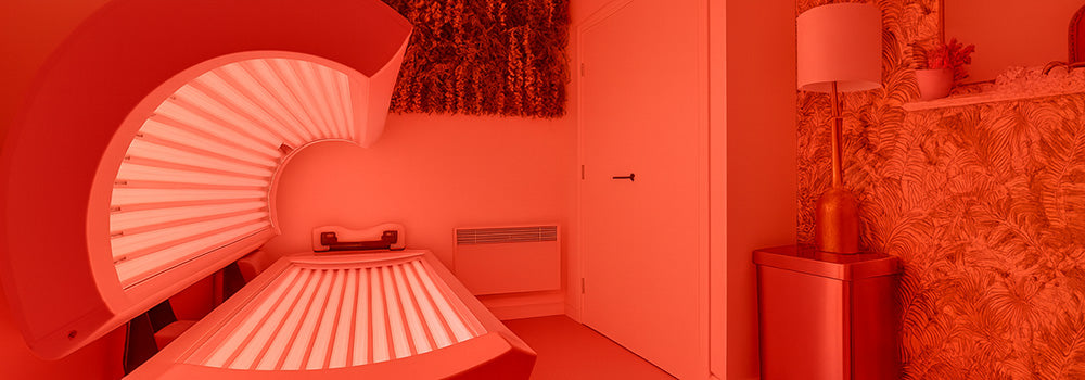 Red light therapy bed in a vibrant botanical wellness room with plant wall and modern decor.