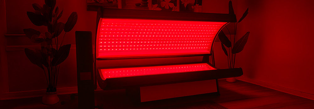 glowing red light therapy bed in a tranquil spa room with plants, artwork, and wooden flooring.
