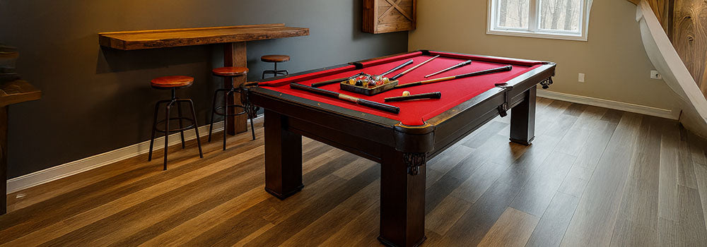 rustic-modern game room with red pool table, wood accents, and pendant lights.