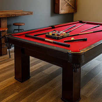 rustic-modern game room with red pool table, wood accents, and pendant lights.