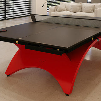 Luxury black and red table tennis table in a modern open-plan living space with marble flooring and soft lounge chairs.