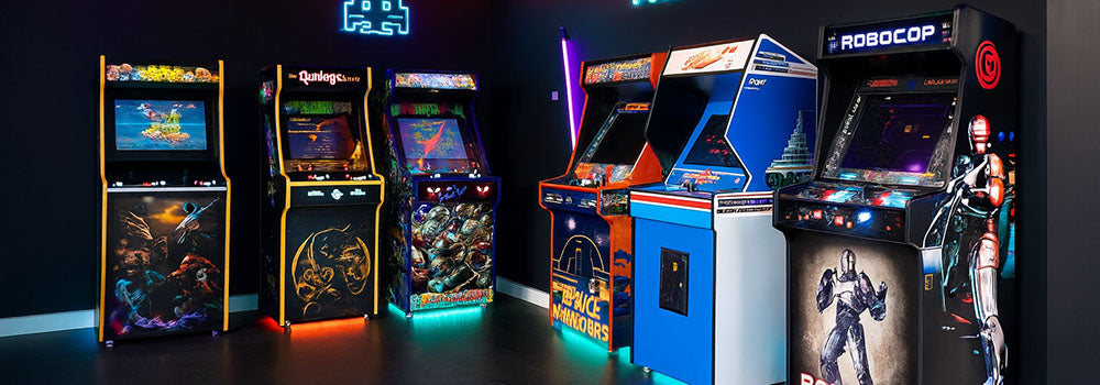 retro arcade room with neon signs and six classic machines including RoboCop, Space Invaders, and Mortal Kombat under industrial ceiling pipes.