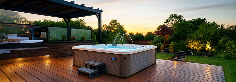 Modern square hot tub with water jets on a wooden deck at sunset.