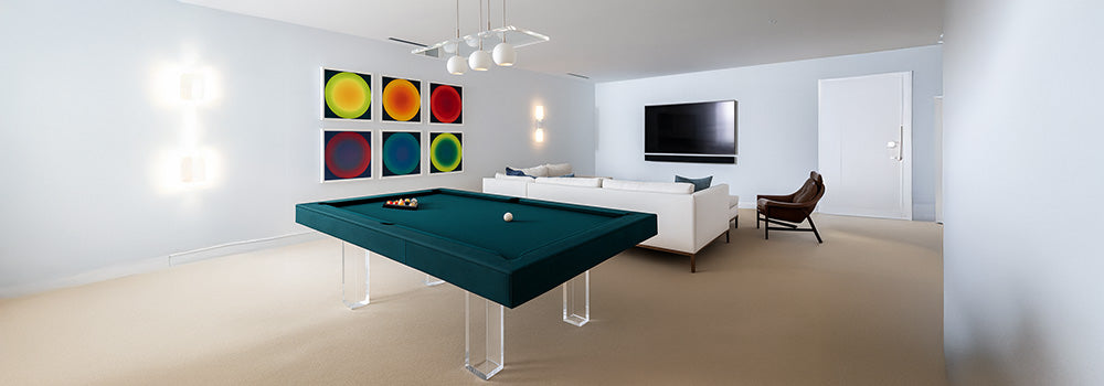 modern teal pool table with acrylic legs in bright living room with abstract wall art and white sofa.