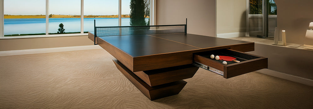 Luxury walnut table tennis table with hidden drawer in a lakeview room with beige carpet and full-height windows.