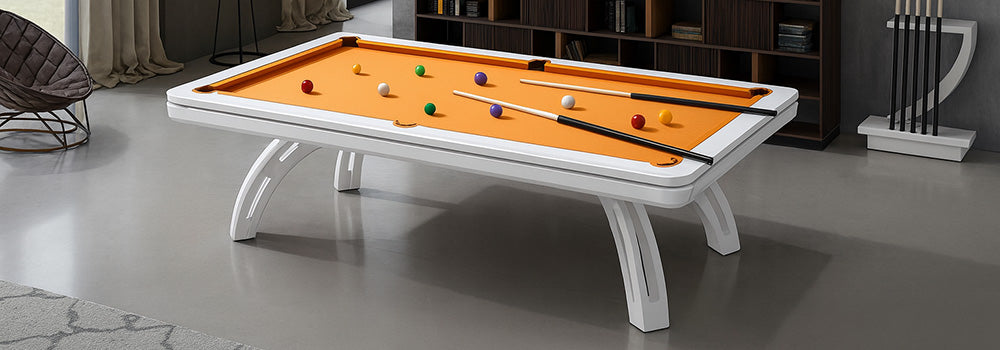 white pool table with orange felt in a modern reading lounge with gray walls and bookshelf backdrop.