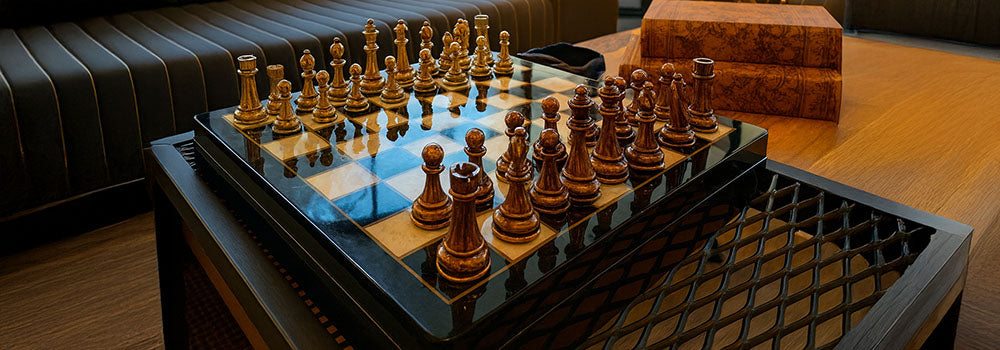 Luxury wooden and gold chess set on glossy marble board in modern lounge with elephant sculpture.