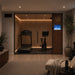 Altitude Centre MetraFit 3000 Active glass-enclosed training pod with warm wood interior and LED strip lighting, containing a treadmill and exercise bike, in an evening home gym with ambient candlelight.