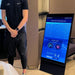 Altitude Centre trainer standing beside the MetraFit Pro vertical touchscreen display showing the session type selection interface with altitude-based training levels