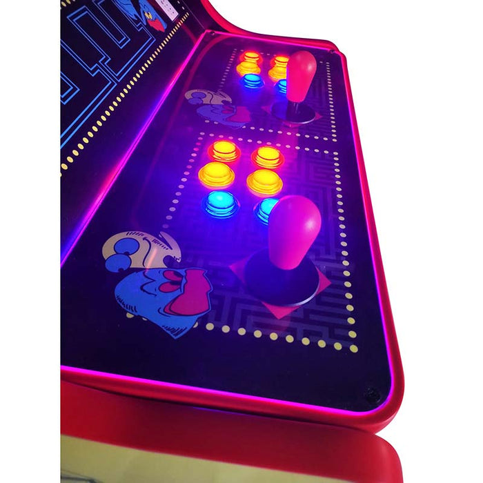 Close-up on illuminated control panel of Pac-Man arcade machine with graphics.