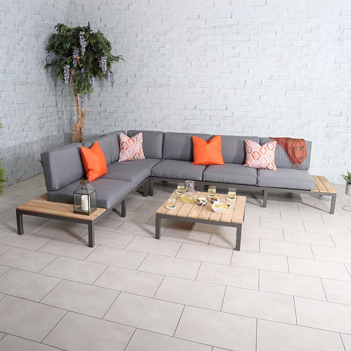 Teak Wood Aspen 6 Seater Corner Lounge Set featuring grey cushions and colourful orange accents, ideal for contemporary indoor spaces.