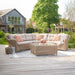 Barakaldo Natural Antique Outdoor Corner Seating Set styled with decorative cushions and a throw, creating a cosy and inviting outdoor space.