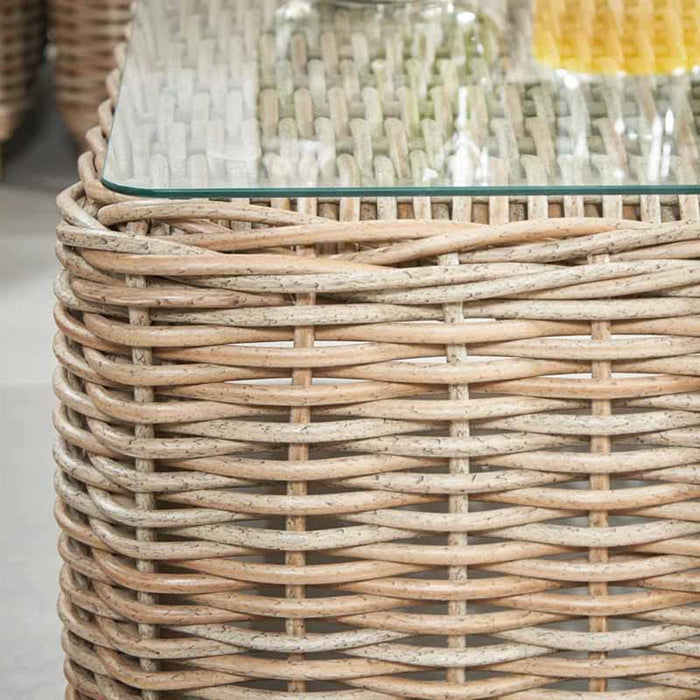 Close-up of the glass top edge on the rattan coffee table, part of the Barakaldo Natural Antique Outdoor Corner Seating Set, highlighting the fine craftsmanship.