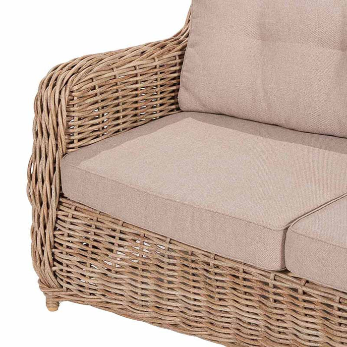 Close-up of the Barakaldo Natural Antique Outdoor Seating Set's armchair, showcasing the detailed rattan weave and plush beige cushions for comfort.