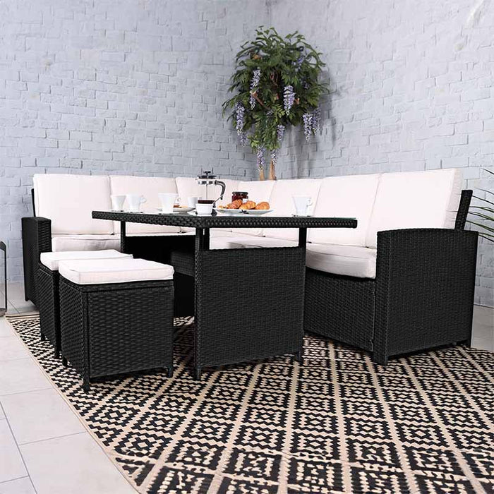 Side view of the Berlin 8 Seater Corner Dining Set in Black with cream cushions, featuring a spacious glass-top table and additional seating for a complete dining experience.