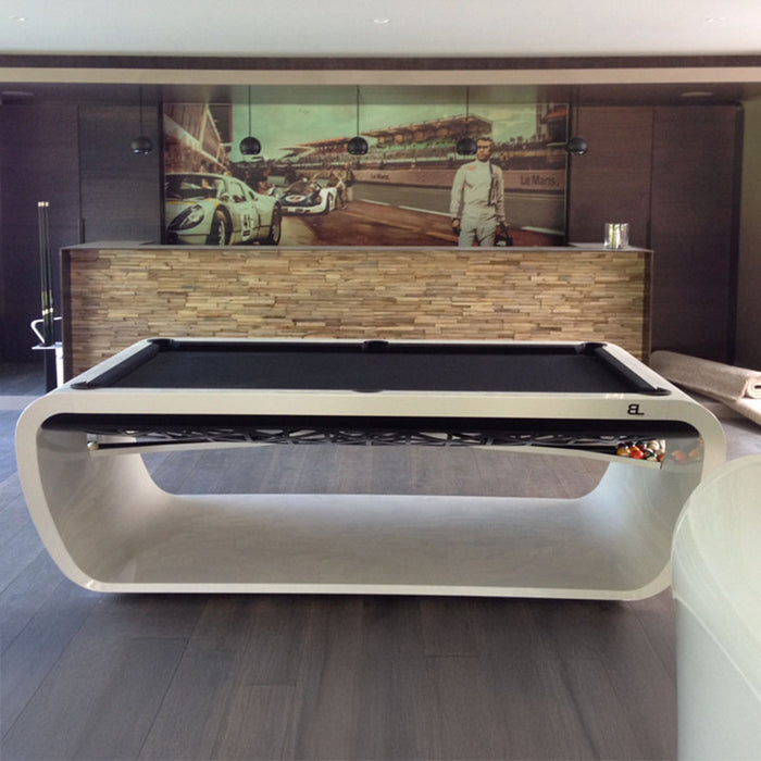 Black felt Billards Toulet Blacklight pool table with white frame in a racing-themed home bar featuring a Le Mans mural.