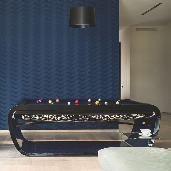 Gloss black Billards Toulet Blacklight pool table with vibrant blue felt placed in a sleek interior with rich textures and dark modern tones.