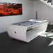 Sleek white Billards Toulet Blacklight pool table with grey felt in a minimalist, sunlit home with modern decor.