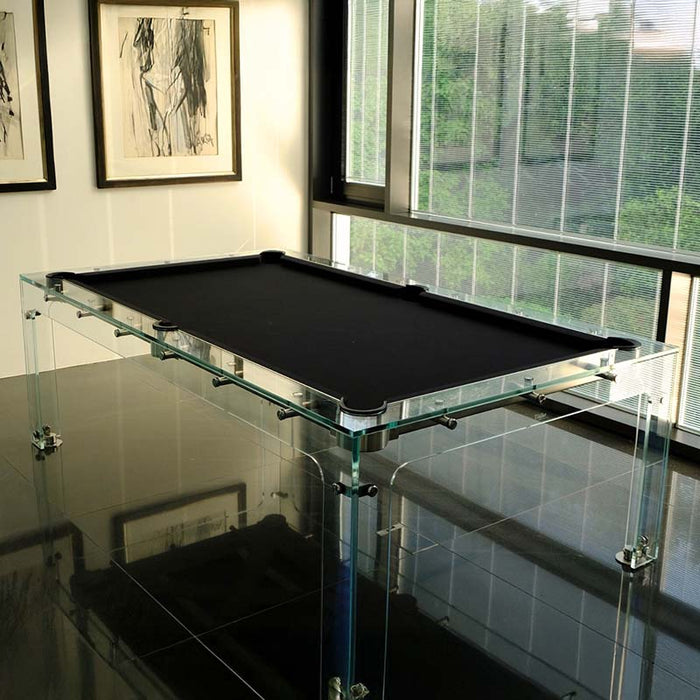 Minimalist black felt Billards Toulet Carat Light pool table with glass frame in a sleek corner room featuring floor-to-ceiling windows and modern art.