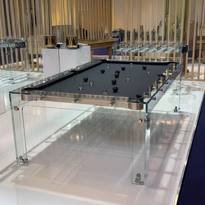 Billards Toulet Carat Light pool table with glass frame and black felt, featuring artistic black and transparent balls on showroom display.