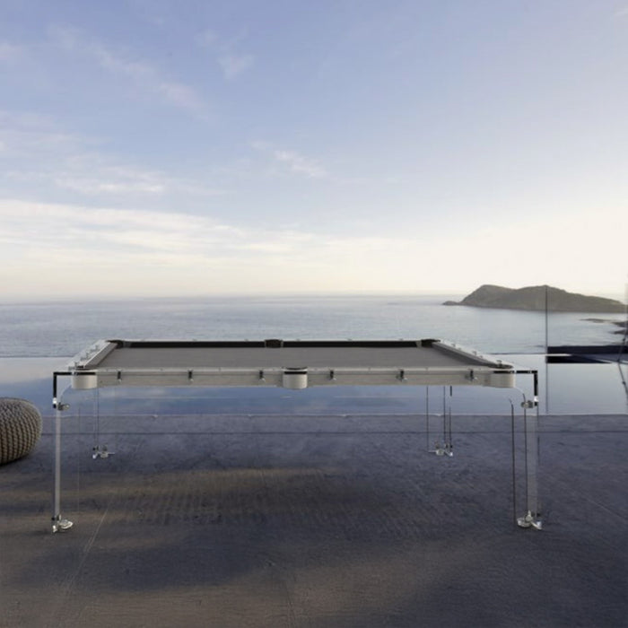 Outdoor installation of the Billards Toulet Carat Light pool table on a clifftop terrace with panoramic ocean views at sunset.