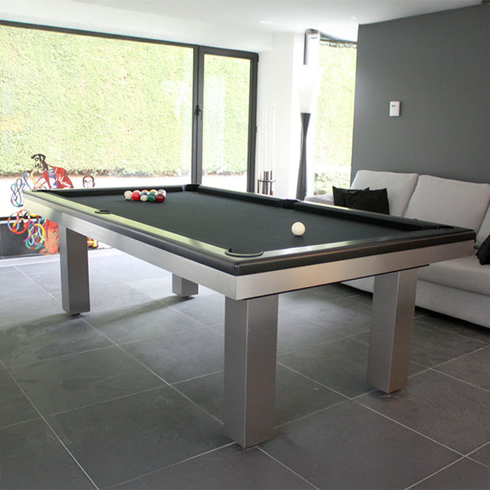Elegant black pool table set beside a large window and grey sofa, blending luxury and modern interior style.