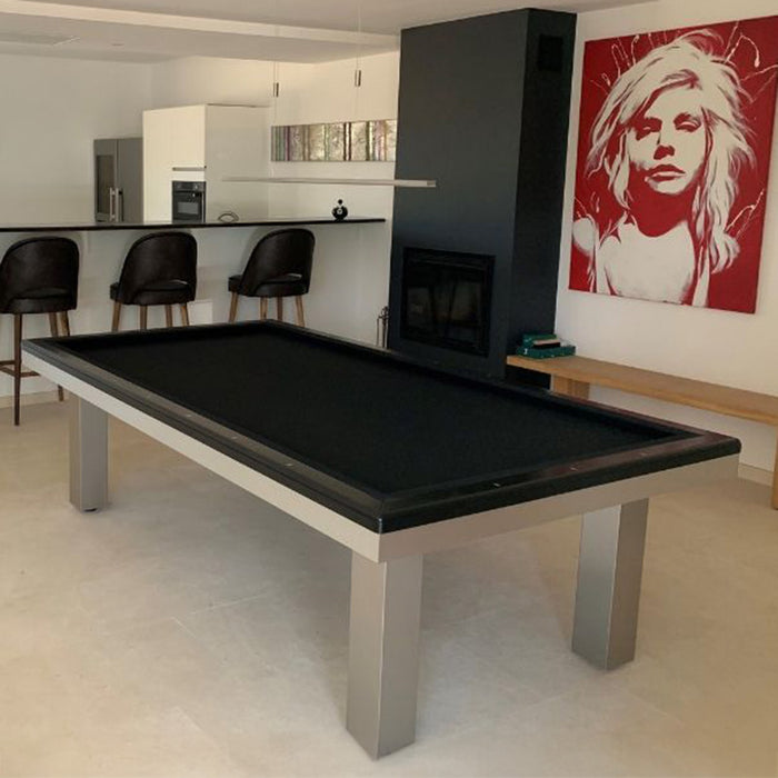 Sleek black billiards table in a stylish open kitchen-diner space with contemporary art and monochrome theme.